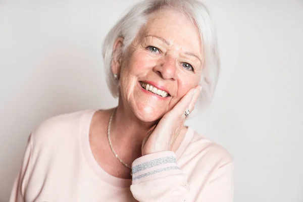 Nice portrait of a retired senior woman on studio background — Stock Photo, Image