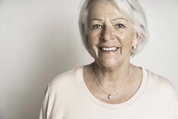 Bonito retrato de una anciana jubilada en el fondo del estudio — Foto de Stock