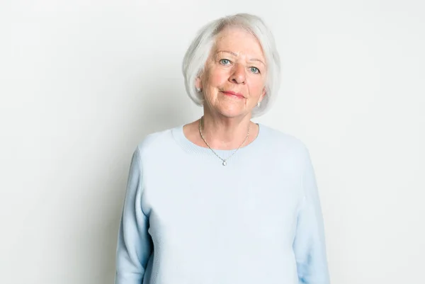 Trevligt porträtt av en pensionerad äldre kvinna på studio bakgrund — Stockfoto