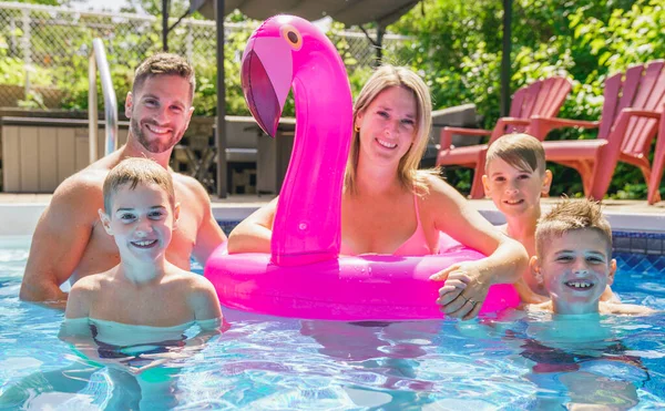 Mãe e pai se divertindo nas férias brincando com seus filhos em uma piscina — Fotografia de Stock