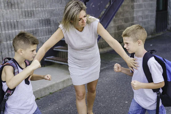 Insegnante fermare due ragazzi che combattono nel parco giochi — Foto Stock