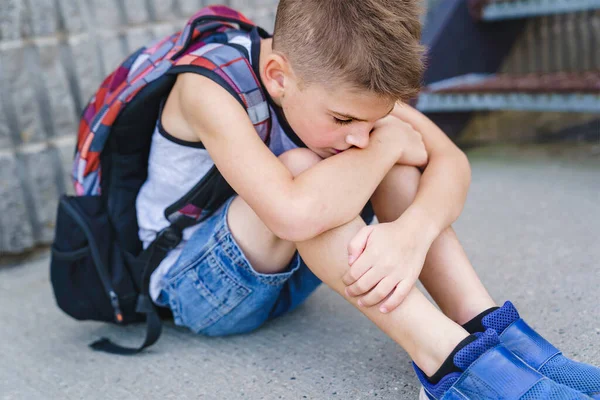 Очень грустный мальчик издевается на школьной игровой площадке. — стоковое фото