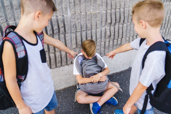 Grausame Teenager schlagen jüngeren Jungen, physische Einschüchterung, Mobbing in der Schule — Stockfoto