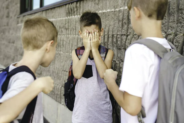 Grausame Teenager schlagen jüngeren Jungen, physische Einschüchterung, Mobbing in der Schule — Stockfoto