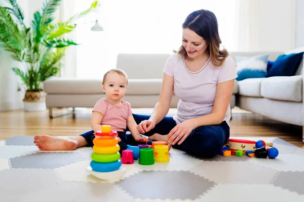 Donna che gioca con il suo bambino in salotto — Foto Stock