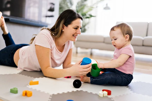 Женщина играет со своим ребенком в гостиной — стоковое фото