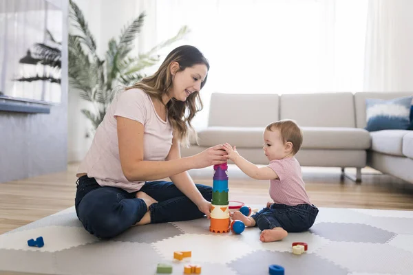 Женщина играет со своим ребенком в гостиной — стоковое фото