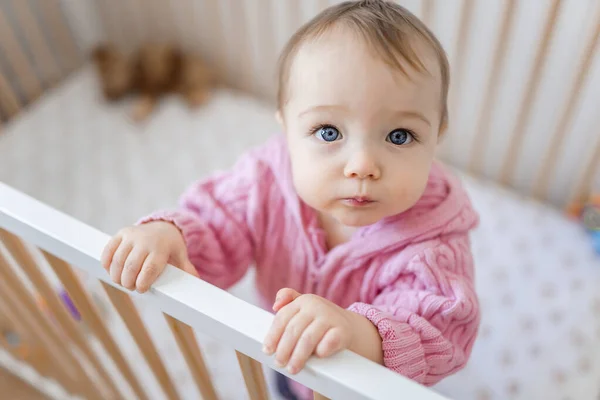 Baby standing in crib in the nursery — Photo