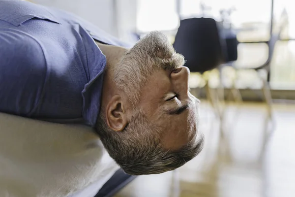 Trevlig mogen man hemma lägenhet med grått skägg avkopplande på sängen — Stockfoto