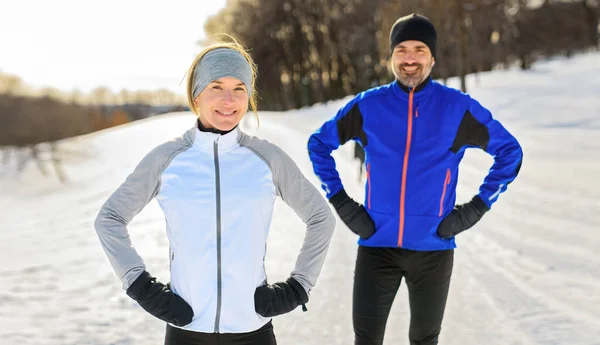 Mature running couple in the winter standing together in nature — Stockfoto