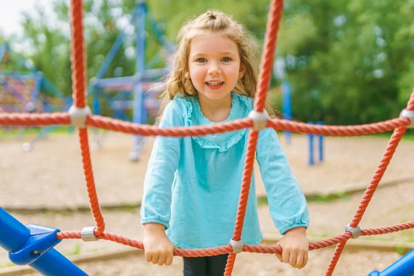 Happy little girl is playground having fun — Stock fotografie