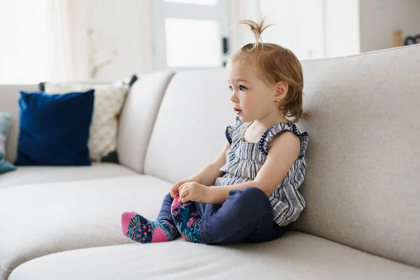 Mignonne petite fille regarder la télévision à la maison — Photo