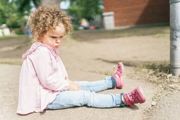 Jovem sentada no chão no parque infantil da escola — Fotografia de Stock