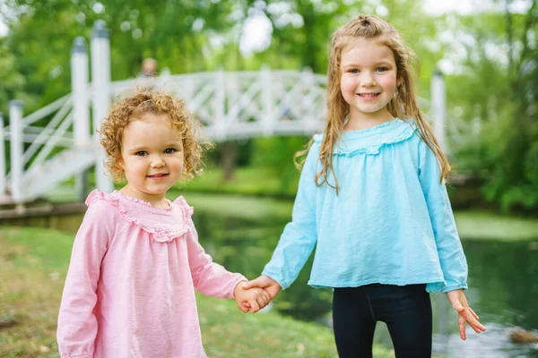Little sister in the summer on nature little girl holding hand — Stockfoto