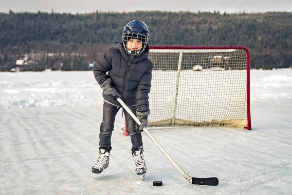 Хлопчик грає хокей на прекрасному озері — стокове фото