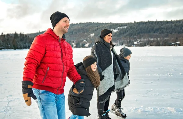 Щаслива сім'я на ковзанах на зимовому озері — стокове фото