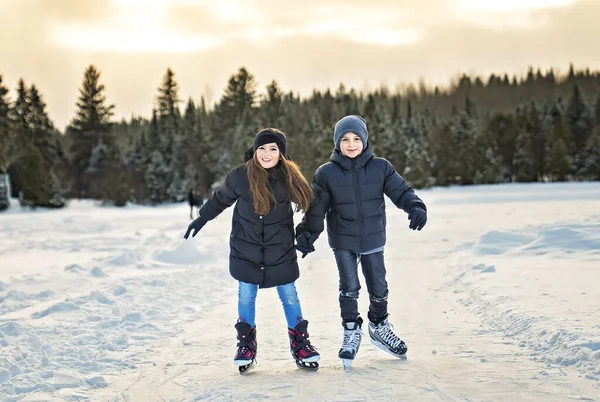 Брат і сестра дитина в термальних костюмах катається на відкритому повітрі — стокове фото
