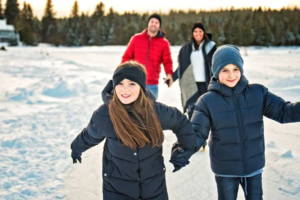 Щаслива сім'я на ковзанах на зимовому озері — стокове фото