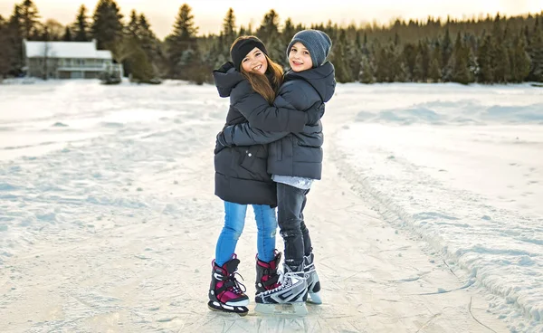 Brother and sister child in thermal suits skating outdoors — Fotografia de Stock