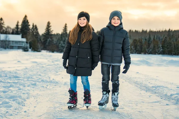 Брат і сестра дитина в термальних костюмах катається на відкритому повітрі — стокове фото