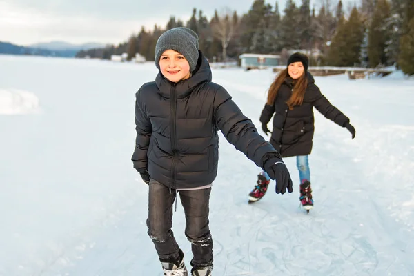 Hermano y hermana niño en trajes termales patinaje al aire libre — Foto de Stock