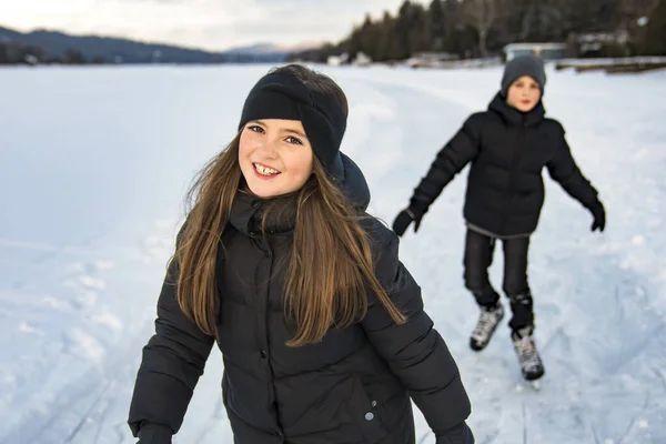 Hermano y hermana niño en trajes termales patinaje al aire libre —  Fotos de Stock