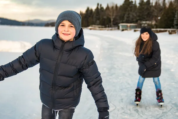 Hermano y hermana niño en trajes termales patinaje al aire libre — Foto de Stock