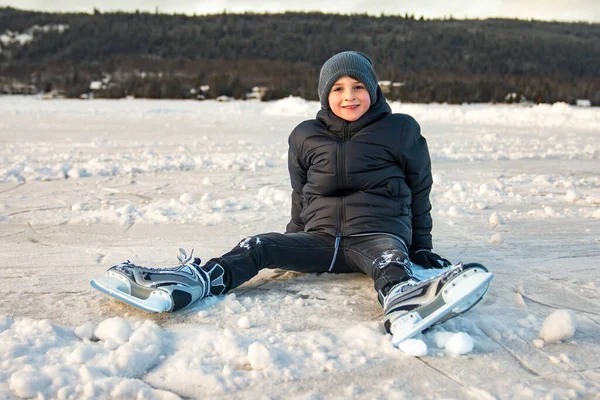 Досить веселий маленький хлопчик в термальних костюмах катається на ковзанах на відкритому повітрі — стокове фото