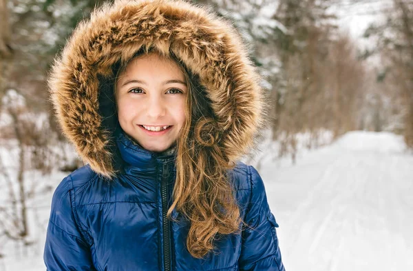 Beautiful child girl outdoors in winter. Snowing. Winter atmosphere — Stockfoto