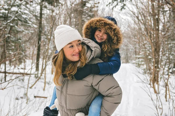 Hermosa madre y su hija se divierten al aire libre en invierno — Foto de Stock