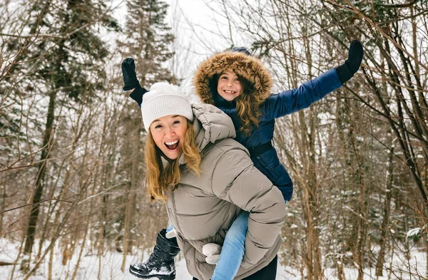 Hermosa madre y su hija se divierten al aire libre en invierno — Foto de Stock