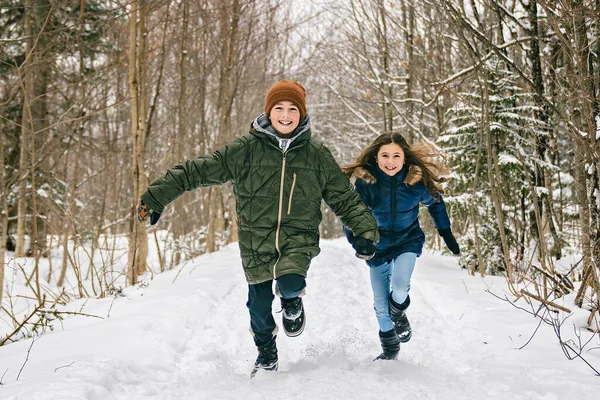 Little girl and boy in winter season running together — Stock Photo, Image