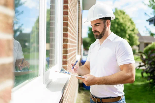 Man with a white hard hat holding a clipboard, inspect house —  Fotos de Stock