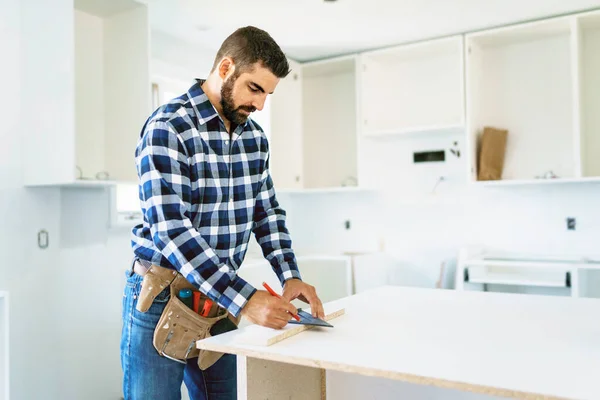 Concentrated young man work with white cabinet in the kitchen —  Fotos de Stock