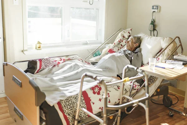 Sick, elderly senior woman in a hospital bed — Stockfoto