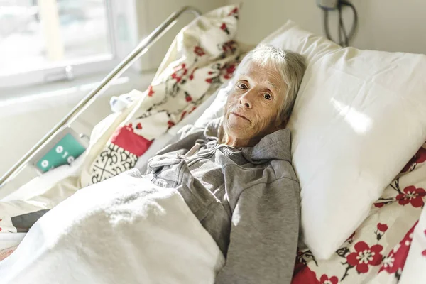 Sick, elderly senior woman in a hospital bed — Stock Photo, Image
