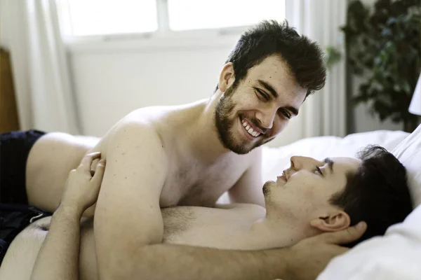 Homosexual couple under a bed at home — Stock Photo, Image