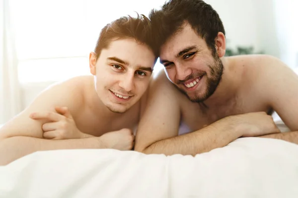 Homosexual couple under a bed at home — стоковое фото