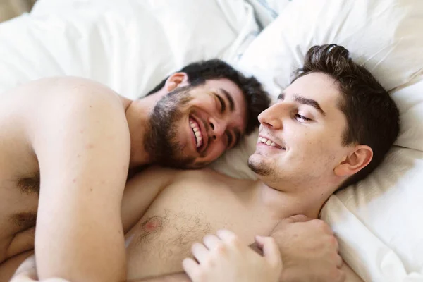 Pareja homosexual debajo de una cama en casa — Foto de Stock