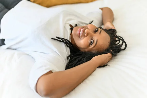 Portrait of an african woman lay on a white bed — Stockfoto