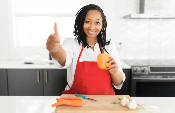 Retrato de una mujer afroamericana haciendo una ensalada saludable en la cocina — Foto de Stock