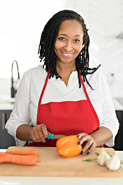 Retrato de una mujer afroamericana haciendo una ensalada saludable en la cocina — Foto de Stock
