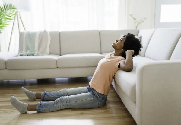 Kvinnan sitter i en soffa hemma i vardagsrummet — Stockfoto