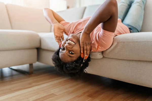 Happy african american woman with headphones listening to music at home — Stok fotoğraf