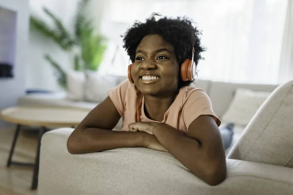 Happy african american woman with headphones listening to music at home — Stock Photo, Image