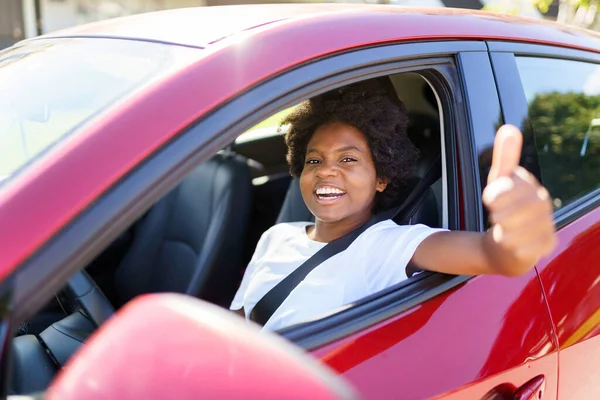 Young black woman sit on is first red car — Photo