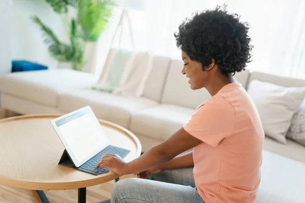 Attrayant jeune femme travaillant avec tablette sur le canapé — Photo