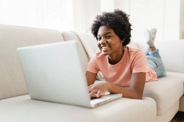 Attrayant jeune femme travaillant avec ordinateur portable sur le canapé — Photo