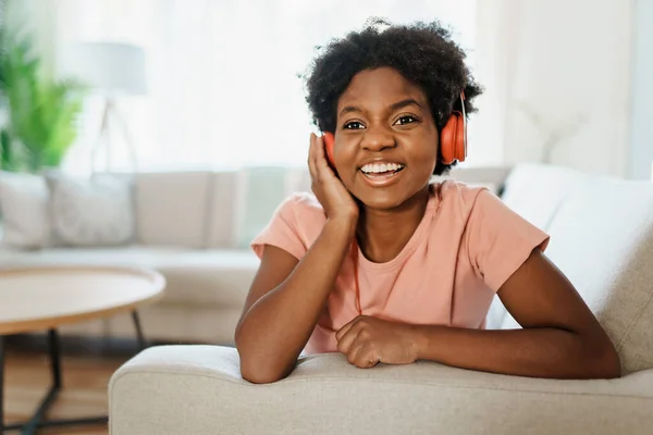 Happy african american woman with headphones listening to music at home — Stock Photo, Image