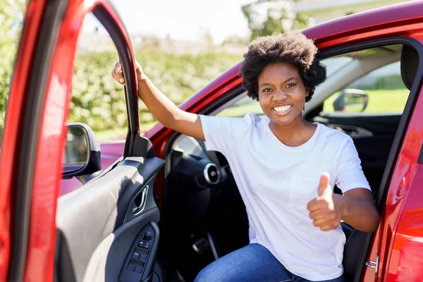 Young black woman with first red car with big thumb up — Photo
